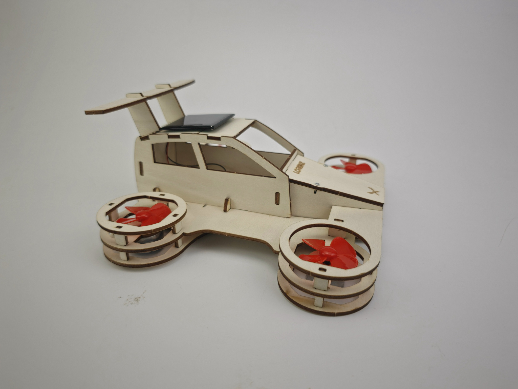 The finished Aeroboticar model kit: a wooden flying car with four red ducted fans, a solar panel on the roof, and LORENZ engraved on the hood