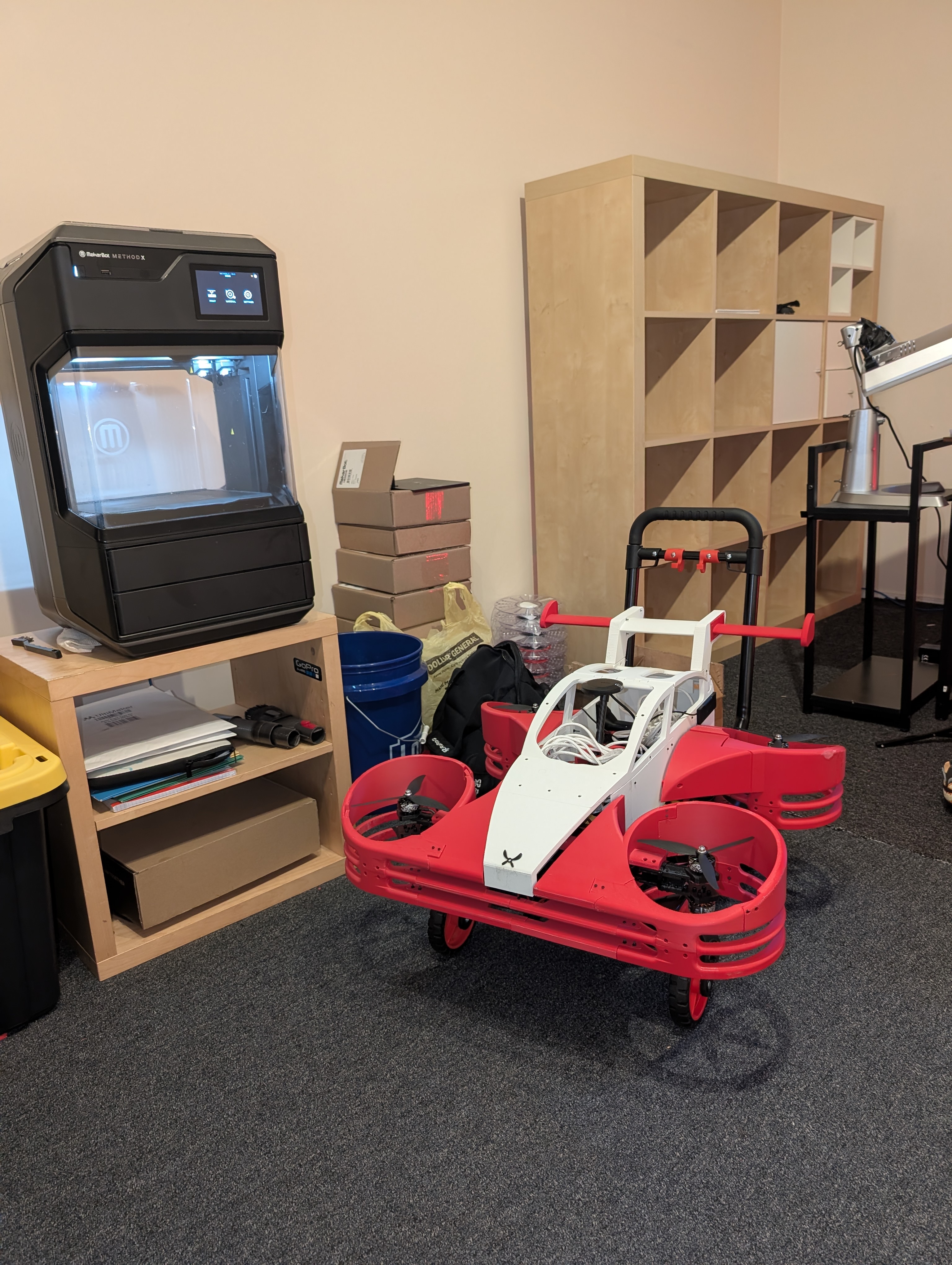 The Aeroboticar flying car prototype, red ducted fans and white body, in the Lorenz workshop